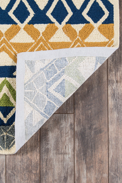 Geometric area rug with blue, mustard yellow and ivory diamonds; folded at corner to reveal pale blue backing on wood floor.