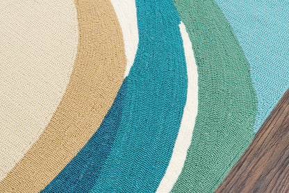 Woven round area rug with curved color bands in beige, tan, teal, blue and green on wood floor.