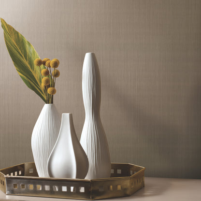 Black grasscloth-style wallpaper with vertical silk texture on a wall in a neutral-toned room.