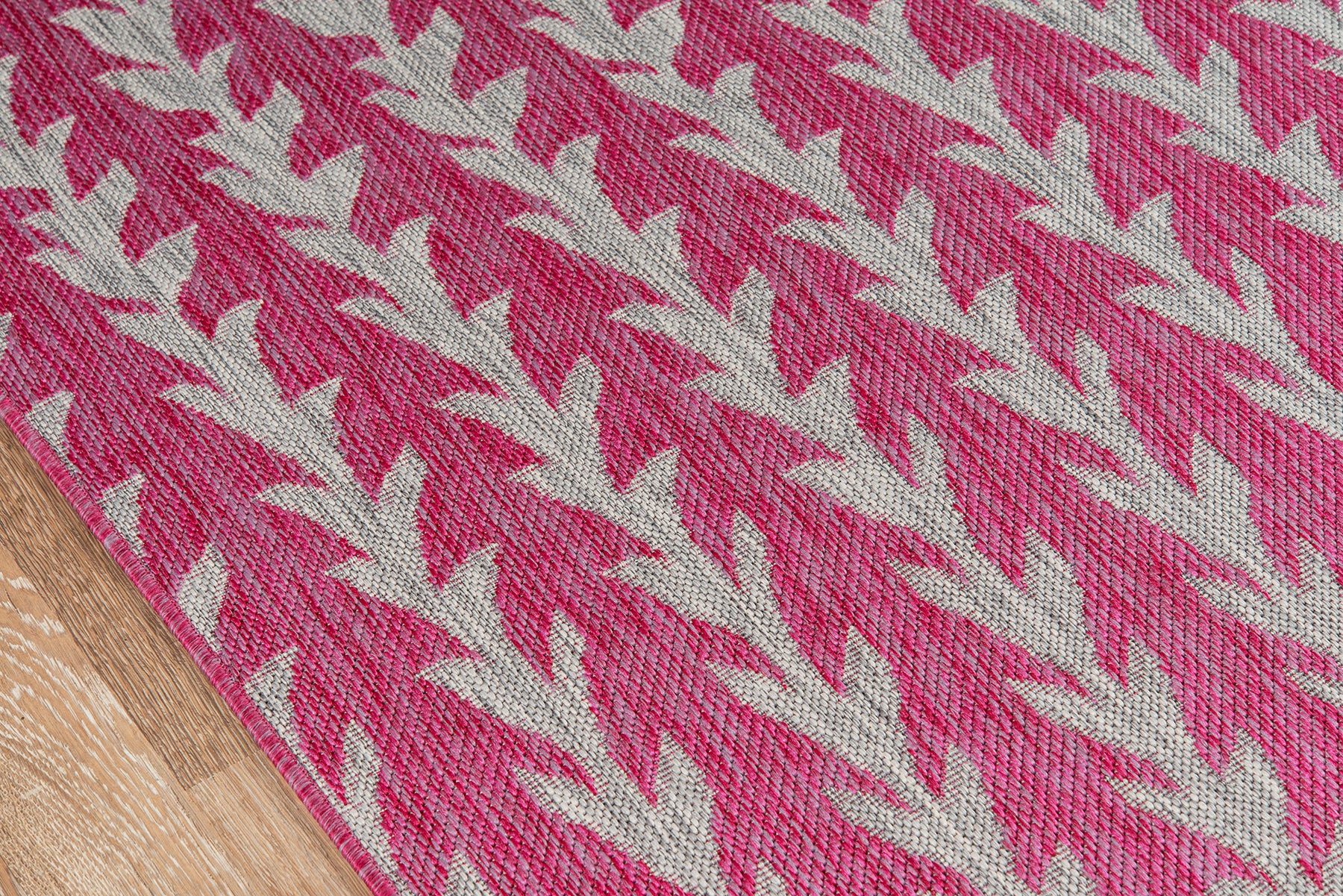 Pink woven runner rug, 2' x 6', with cream chevron/leaf pattern on a wooden floor.
