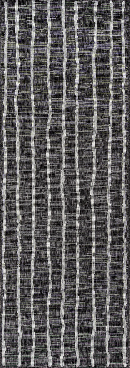 Charcoal rug with slim irregular white vertical stripes; textured modern striped pattern.