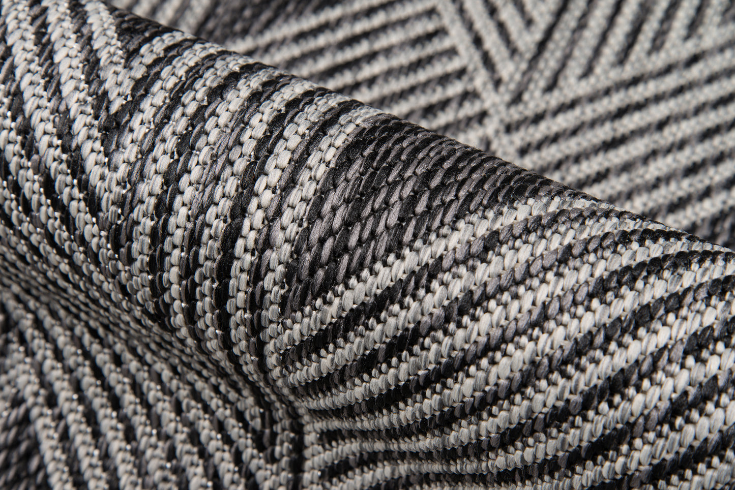 Close-up of black and white herringbone woven rug with a textured striped pattern.