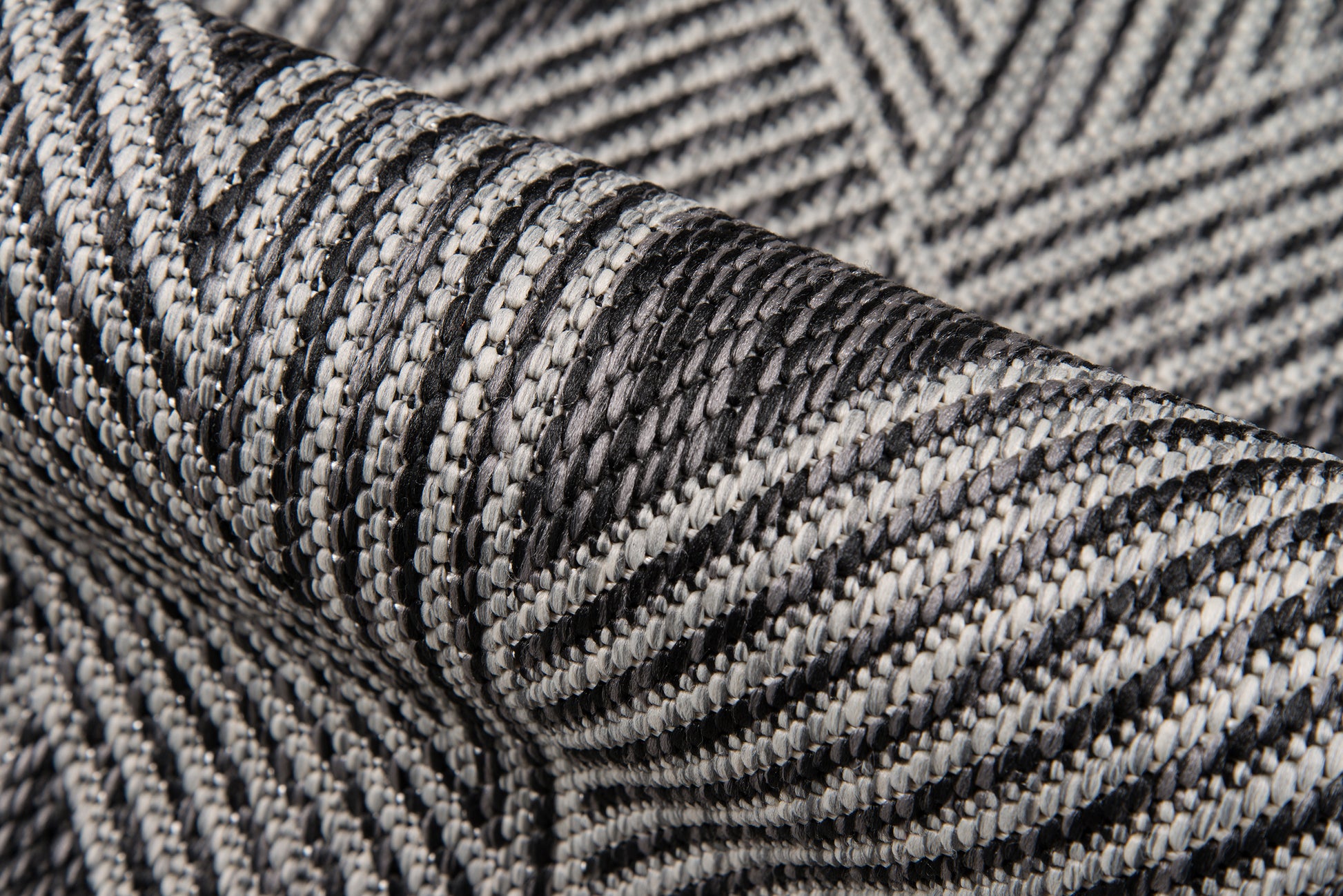 Close-up of black and white herringbone woven rug with a textured striped pattern.