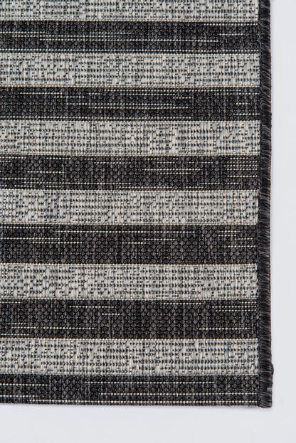 Woven striped rug in charcoal and light grey with textured weave and bound edge.