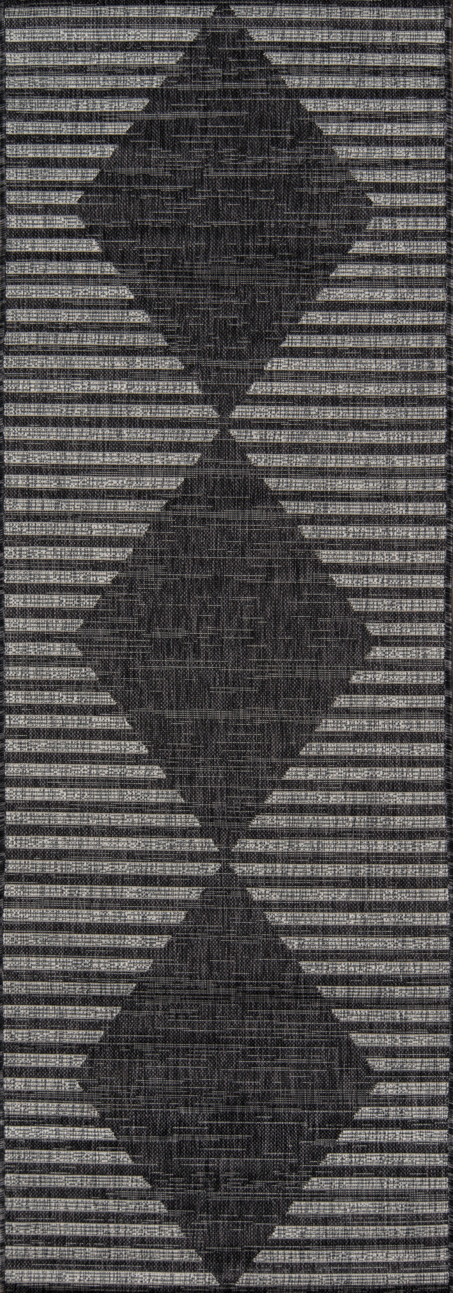 Woven rug featuring three stacked charcoal diamonds on a light gray striped backdrop.