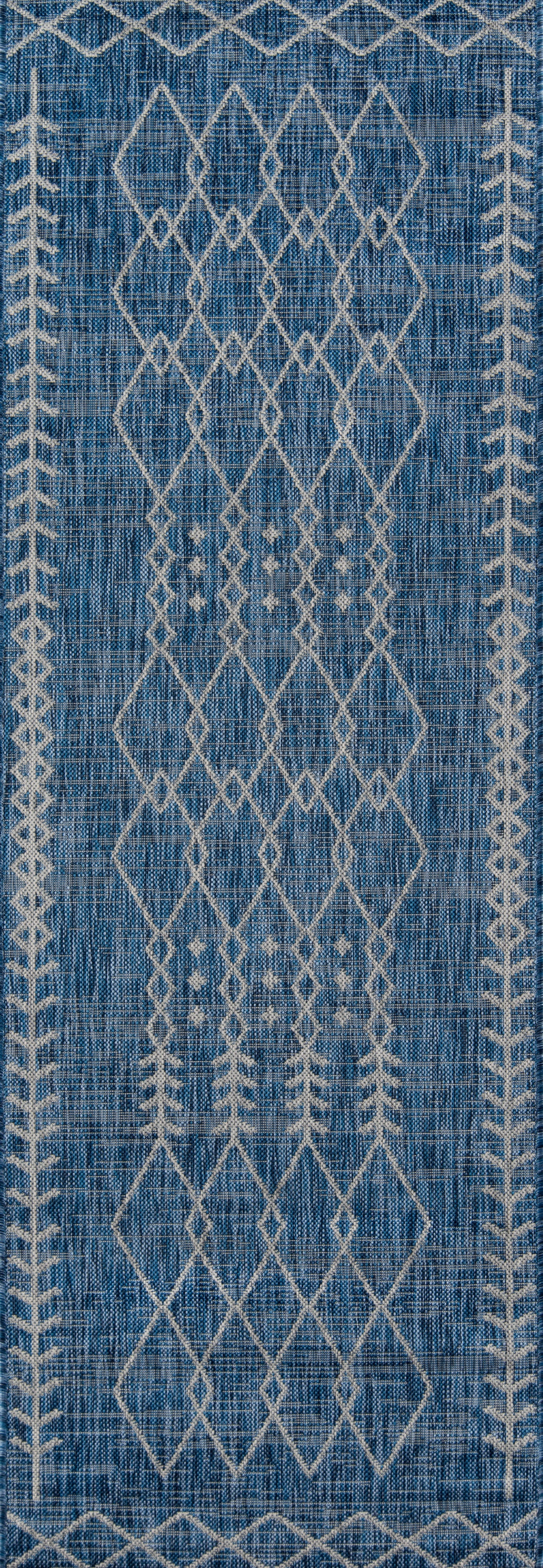 Blue woven rectangular rug with cream diamond lattice pattern and border accents; boho Moroccan-inspired style.