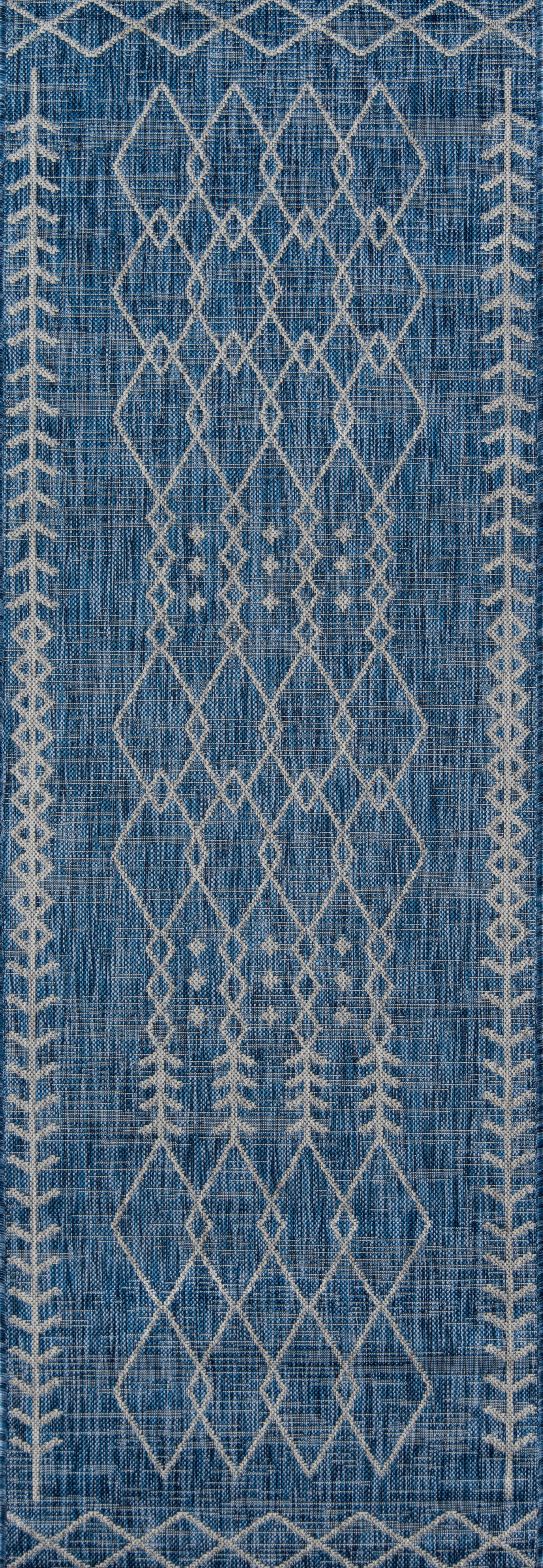 Blue woven rectangular rug with cream diamond lattice pattern and border accents; boho Moroccan-inspired style.