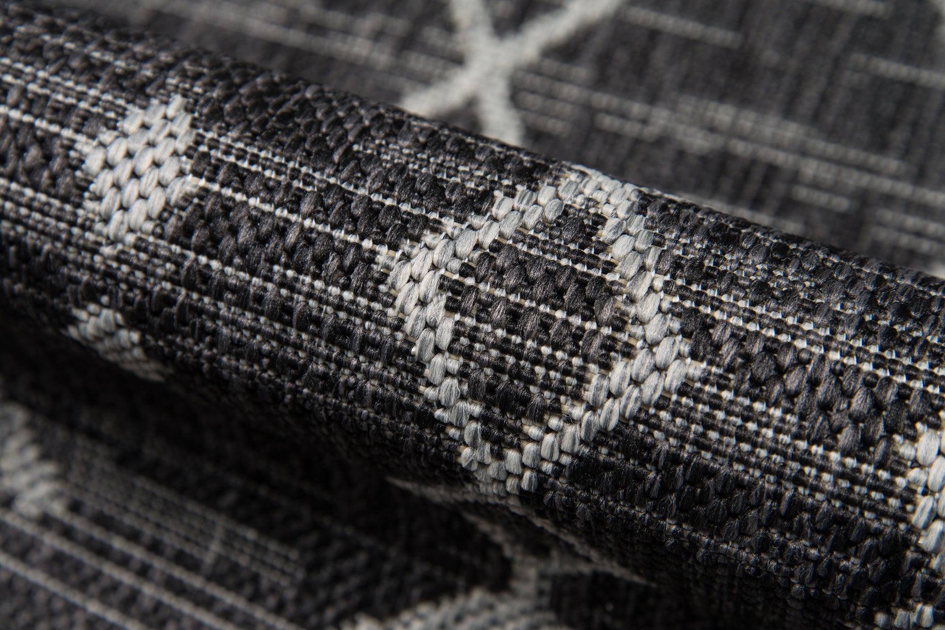 Close-up of dark gray woven fabric with a white geometric diamond pattern; 2' x 10' rug runner.