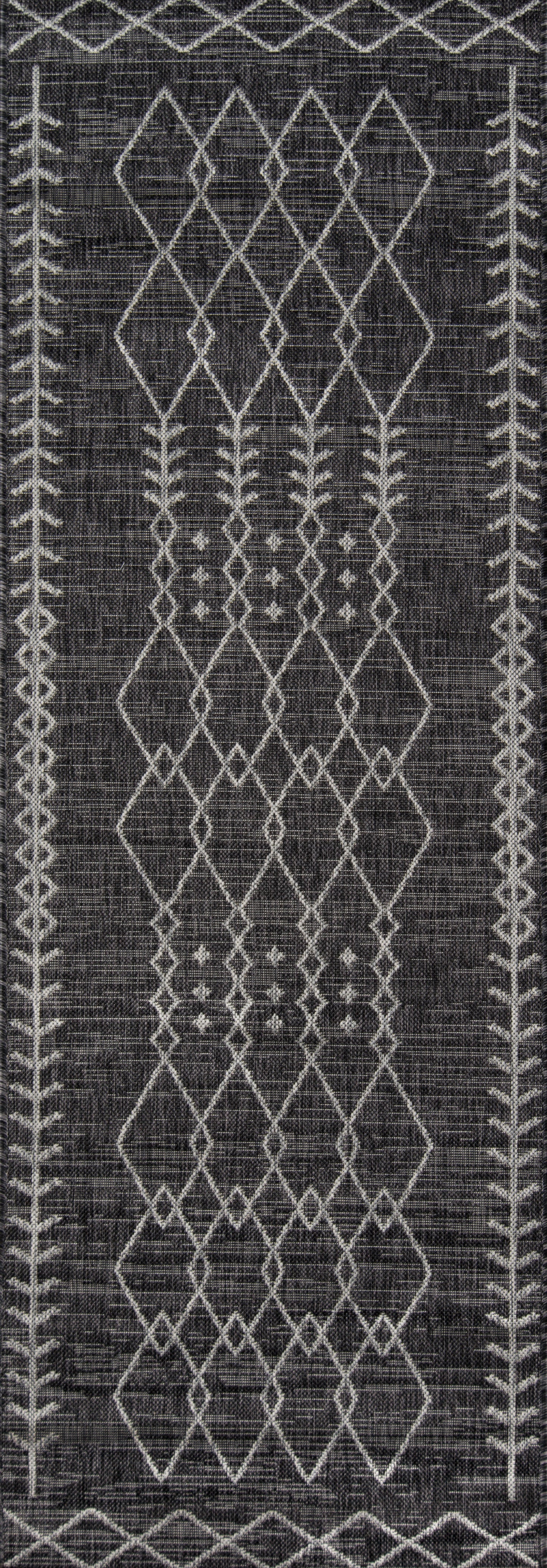Dark gray woven rug with white geometric diamond lattice and repeated border leaf motifs; kilim style