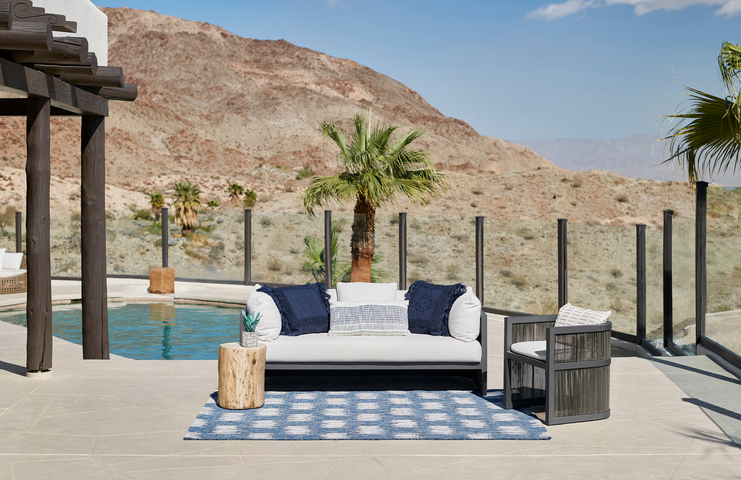 Blue outdoor rug laid on a poolside patio.