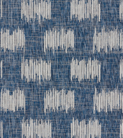 Denim blue woven rug with white rectangular ikat motifs; textured floor textile, 2' x 3'.