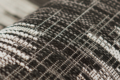 Close-up of a black and white plaid tweed rug runner with a chunky weave and textured grid pattern, 2' x 6'.
