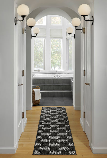 Black-and-white zigzag rug runner on light wood hallway floor, size 4' x 6'.