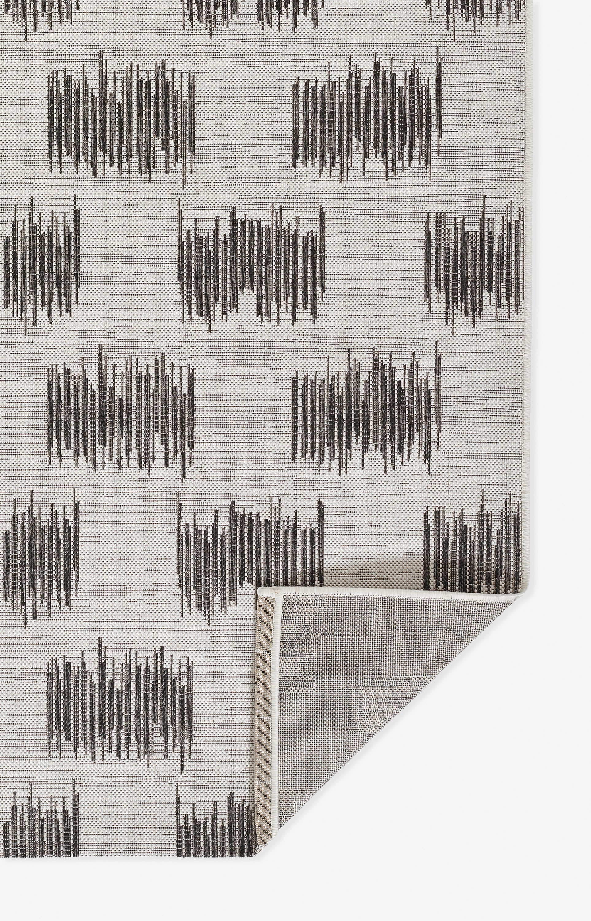 Ivory rug with dark charcoal brushstroke grid pattern; contemporary woven texture.
