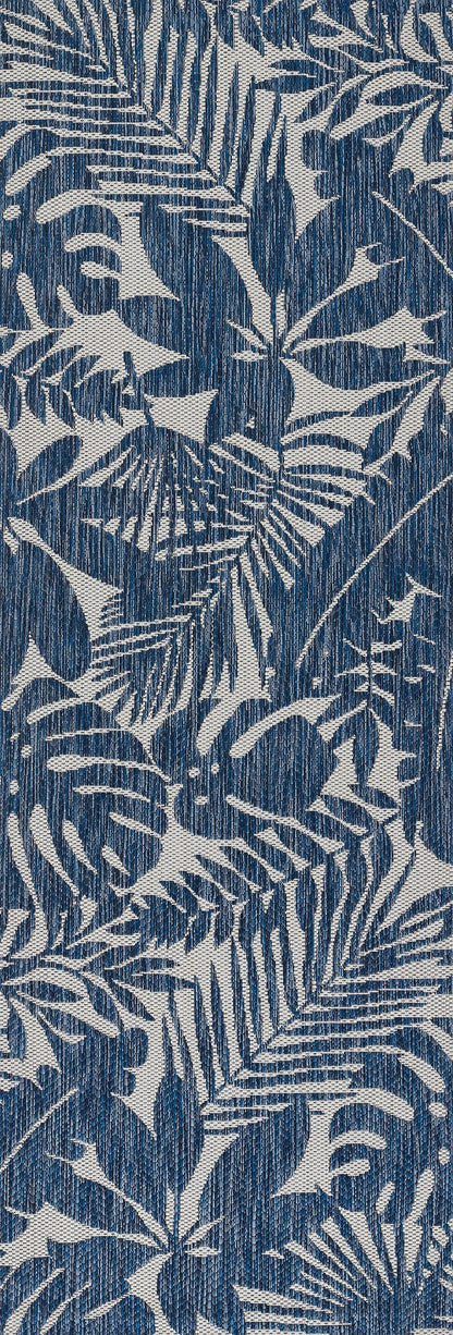 Blue rug with white tropical palm and fern leaf print; denim-like texture; 9' x 13'.