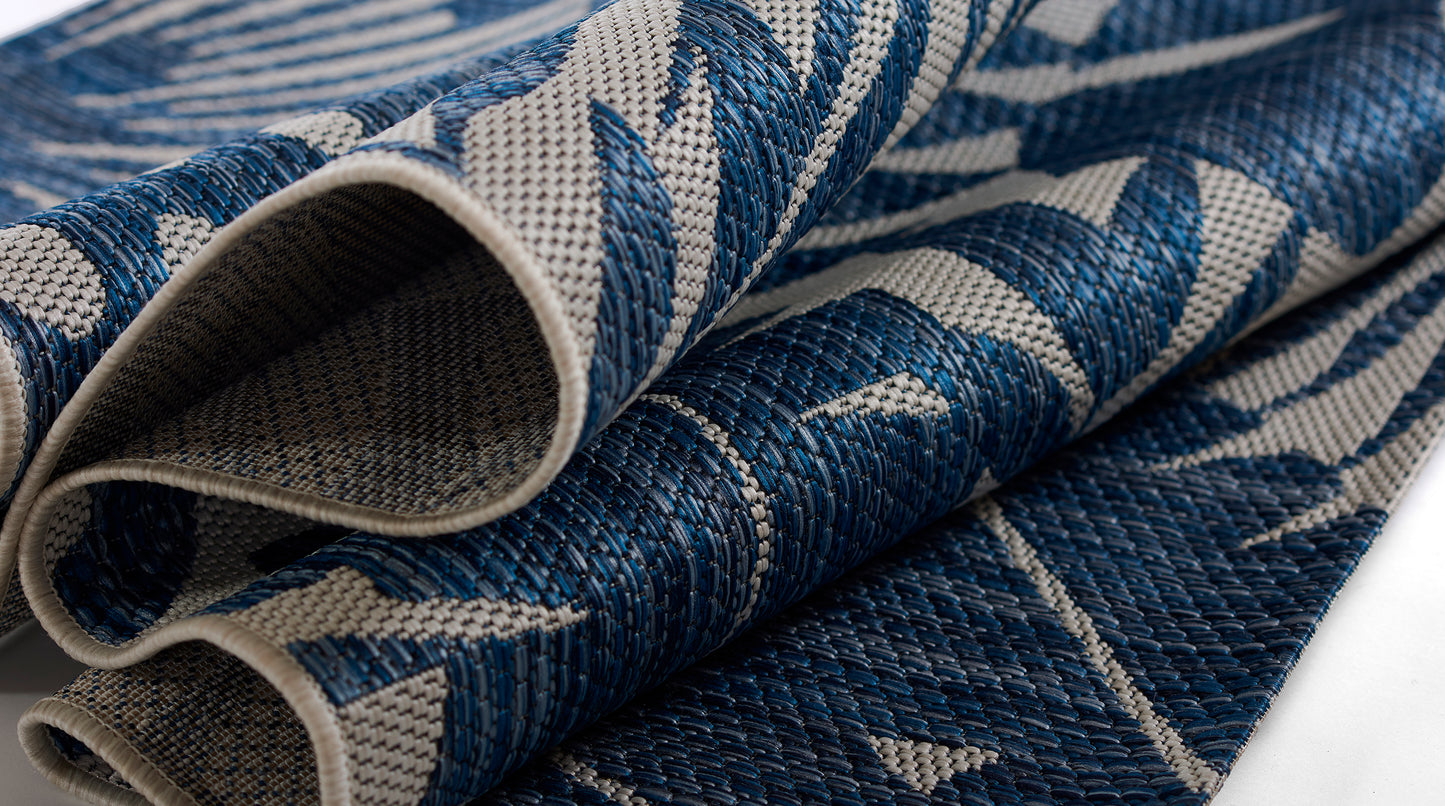 Villavi-13Blu blue and beige woven rug fabric with bold leaf pattern, rolled edges, textured textile.