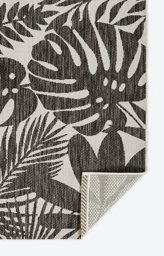 Rectangular rug with dark brown tropical leaf pattern on beige background; woven textured finish.