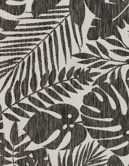 Dark charcoal and ivory tropical leaf print rug runner with a linen-like texture; fern and palm fronds motif.
