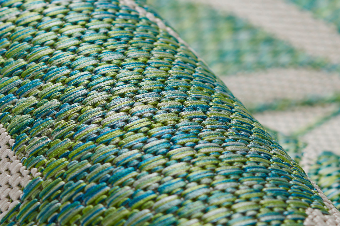 Close-up of green and teal woven raffia with lime accents in a diagonal braid pattern.