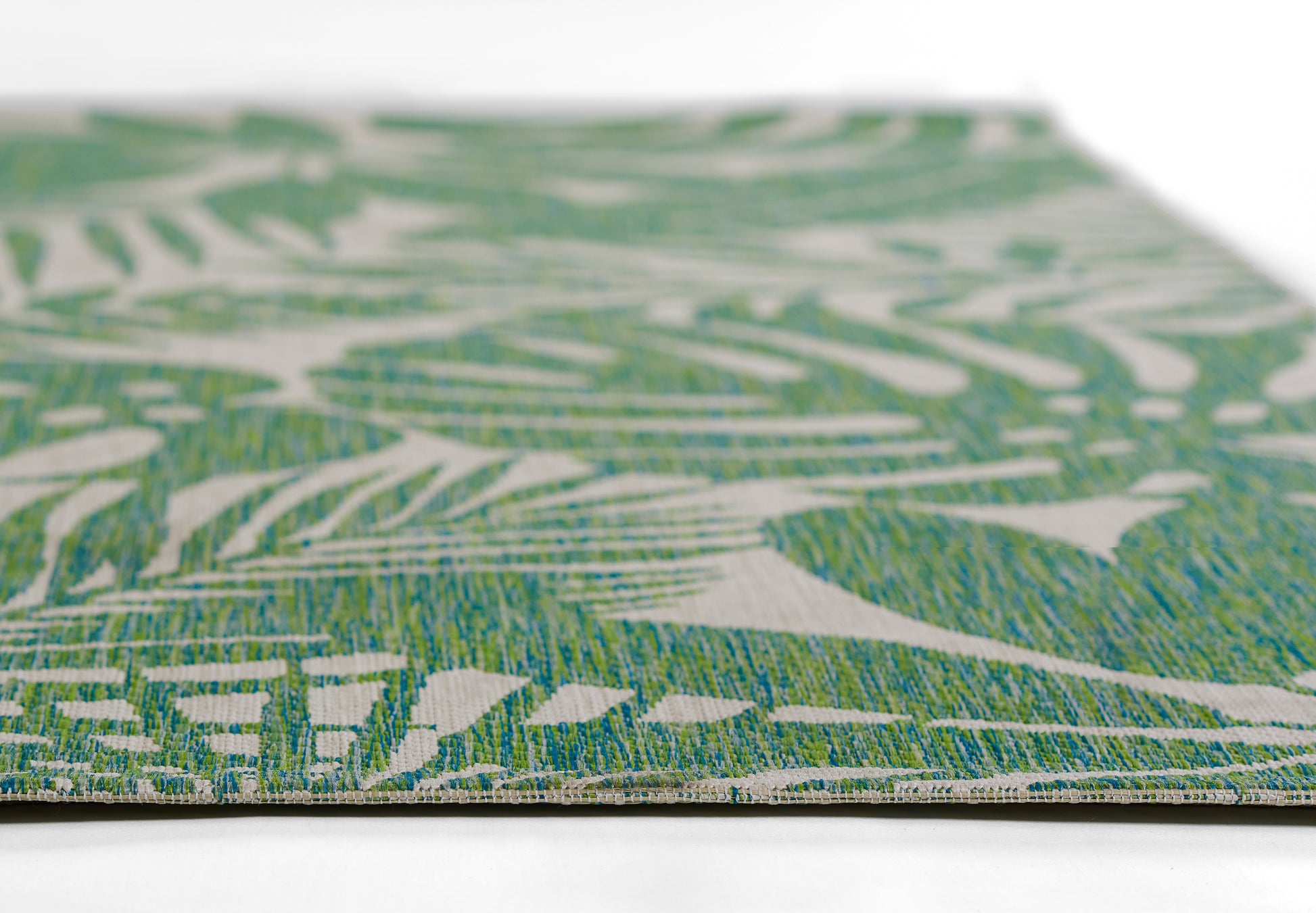 Green and white botanical pattern woven rug, rectangular decorative floor mat, tropical style.