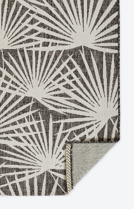 Grey fabric with a white sunburst/starburst motif; folded corner visible, geometric textile.