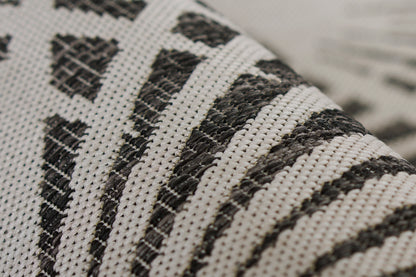 Close-up of black & white striped, woven rug with a textured grid pattern.