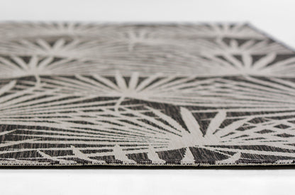 Close-up of a black & white palm-leaf patterned rug with a low-pile weave.