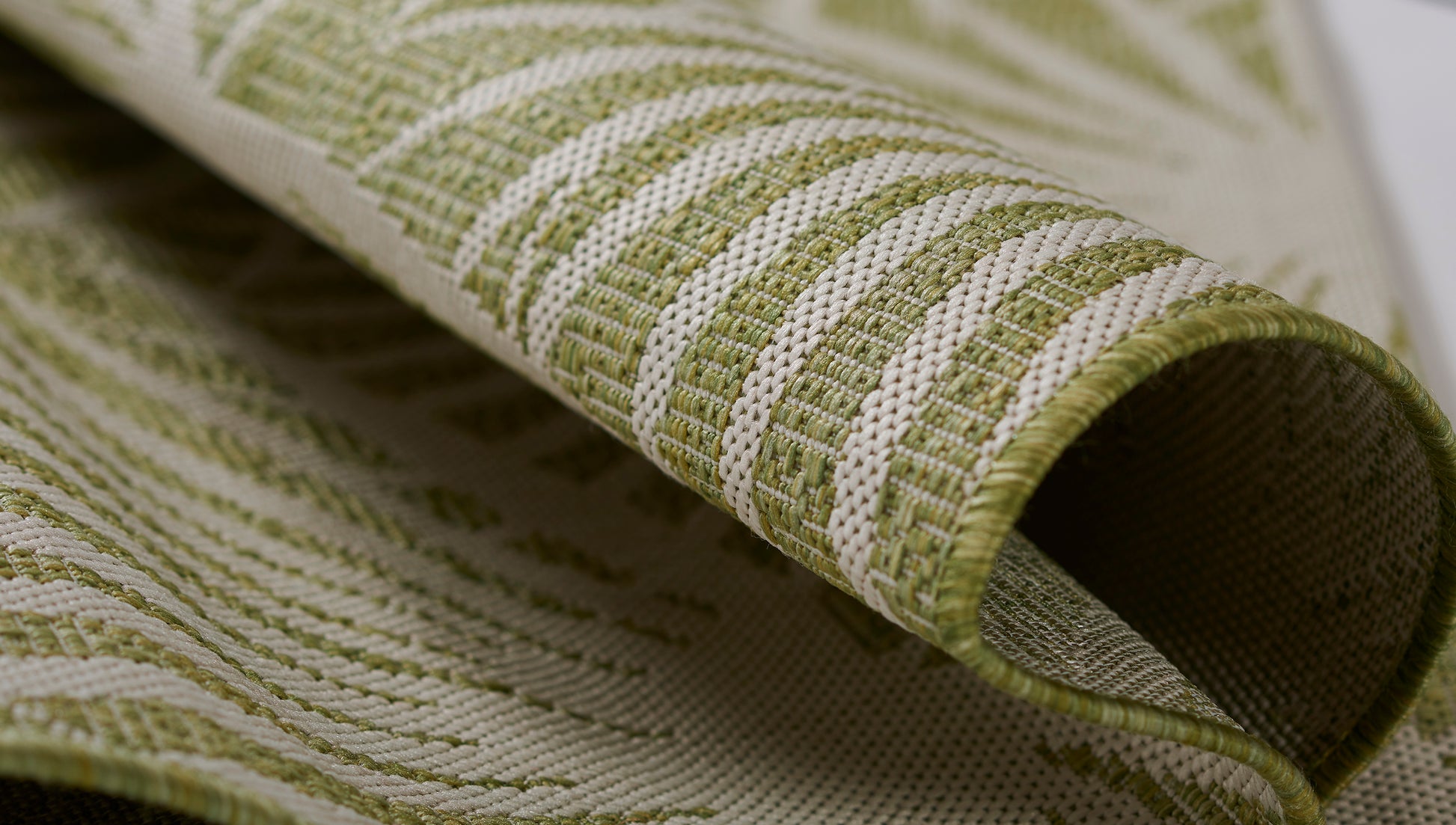 Green & white striped woven rug with a textured surface and rolled edge.