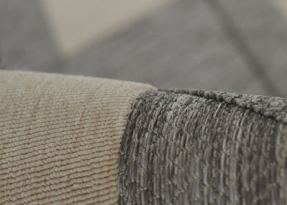 Close-up of two-tone woven rug: beige and gray textured loop-pile for a modern neutral style.