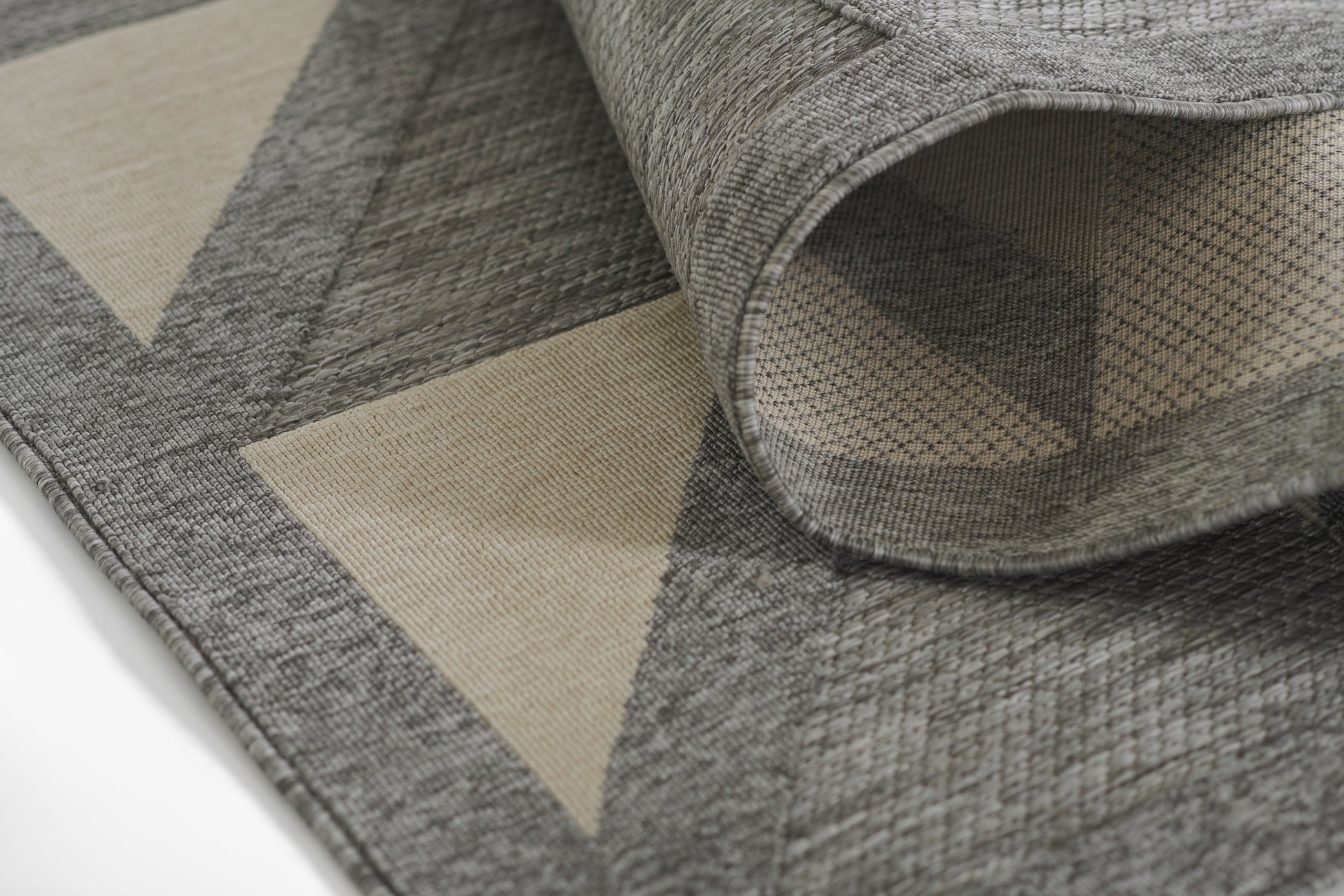 Grey woven runner rug with beige triangle geometric pattern, textured weave, folded edge.