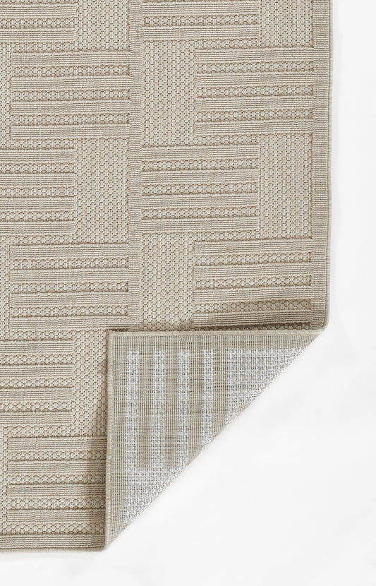 Beige geometric woven rug with blocky striped panels; cream underside visible, neutral modern decor.