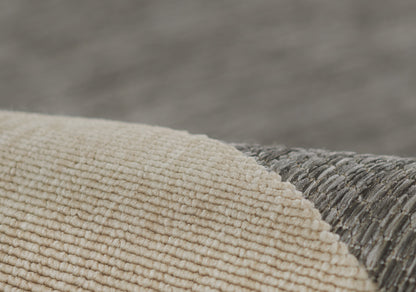 Close-up of beige ribbed runner texture overlapping a gray textured rug, warm modern decor.