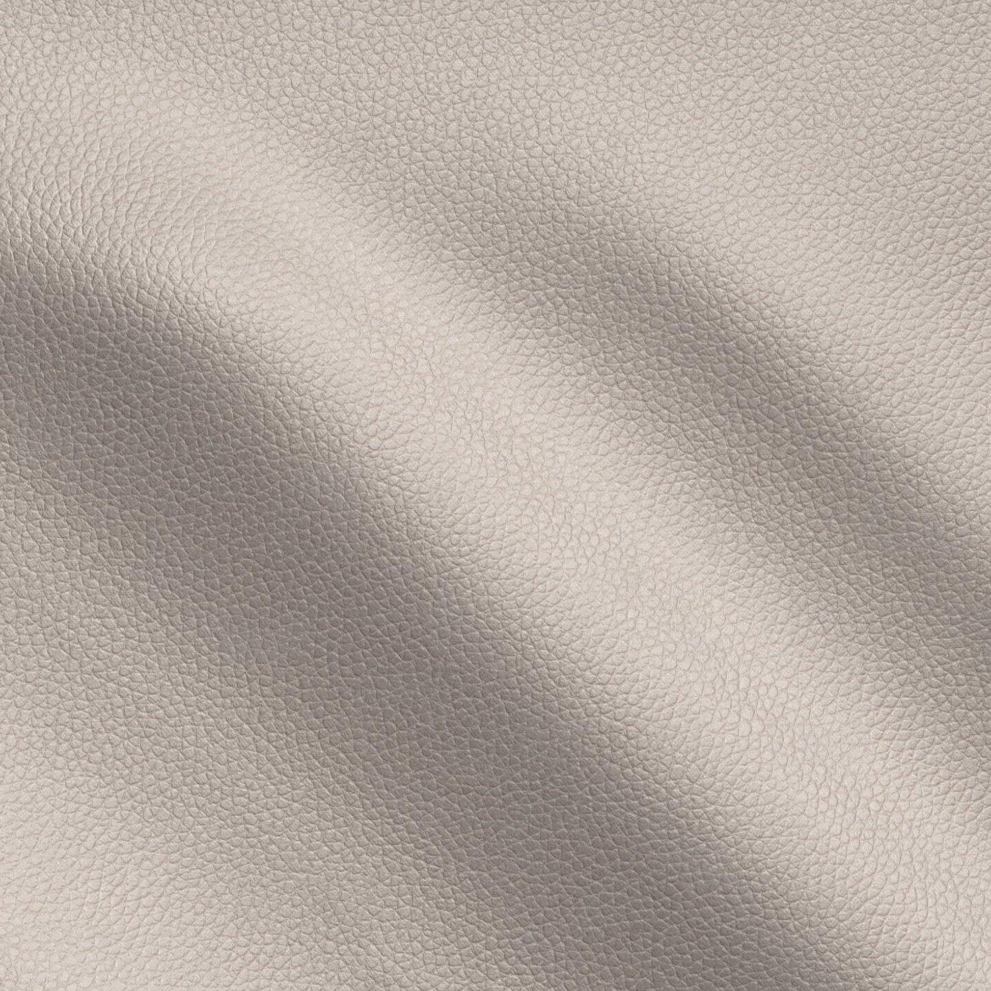 Brown pebbled vegan leather texture close-up with soft creases, leather-look vinyl fabric.