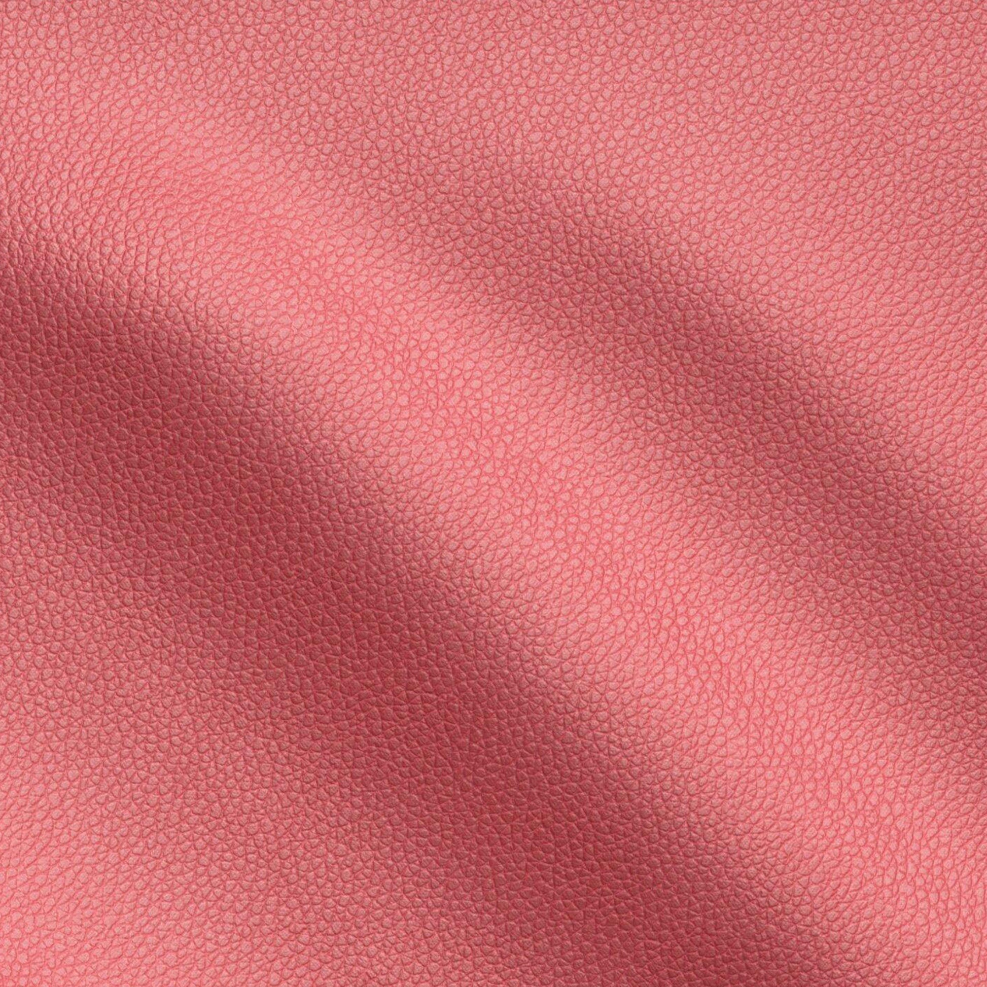 Red pebbled vegan leather texture close-up with soft folds.