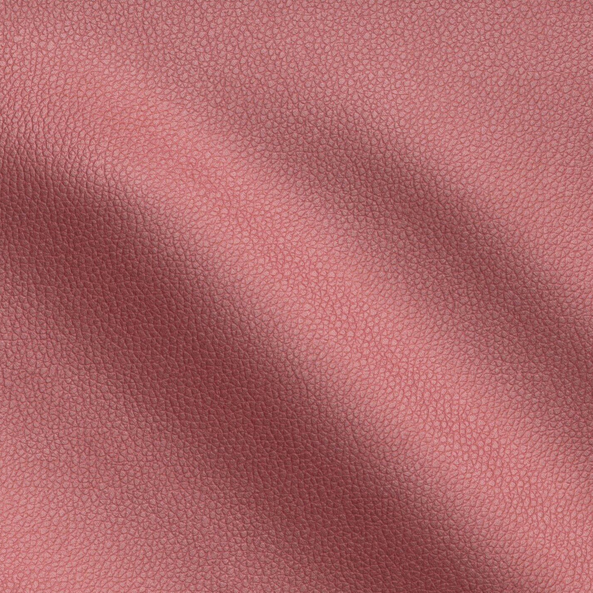 Close-up of red vegan leather with a pebbled texture and soft folds.