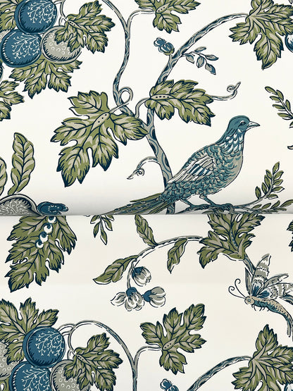 Floral toile pattern with blue-green birds perched on leafy vines and blue fruit on ivory background.
