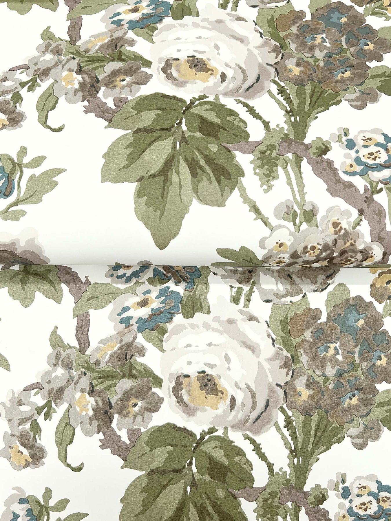Patterned fabric with white roses, green leaves, and blue-beige blossoms on cream background.