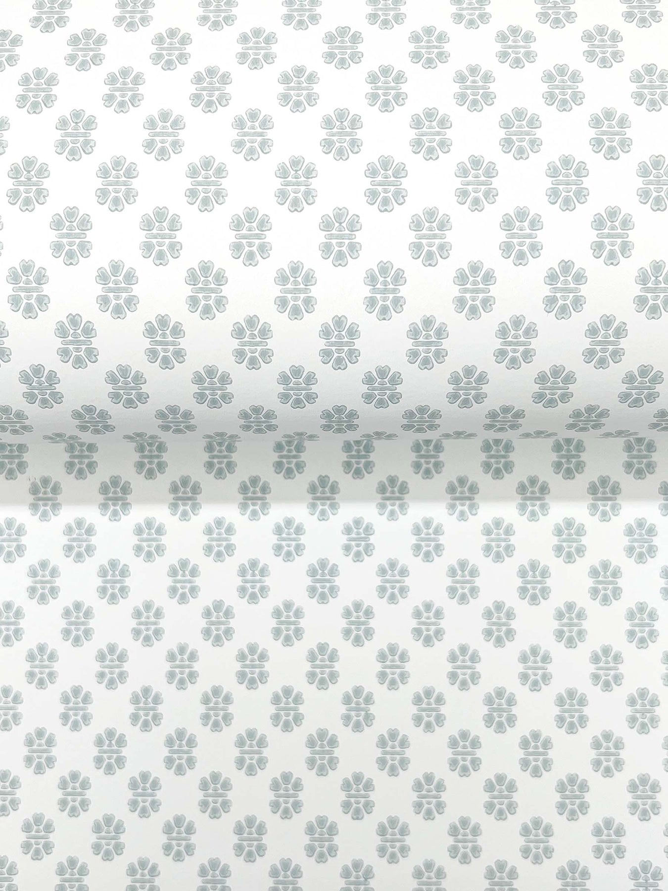 Pastel blue-gray quatrefoil floral pattern on white wallpaper, repeating grid.