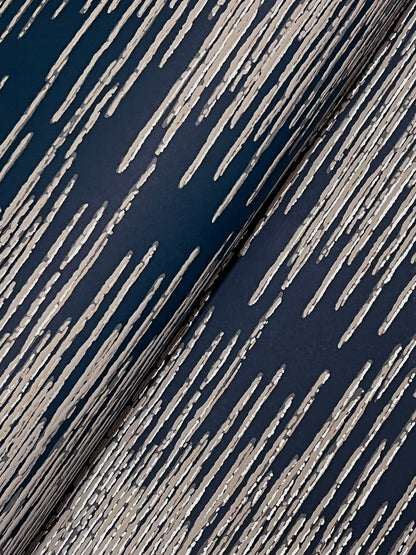 Close-up of navy blue fabric with cream diagonal streaks, creating a distressed striped pattern.