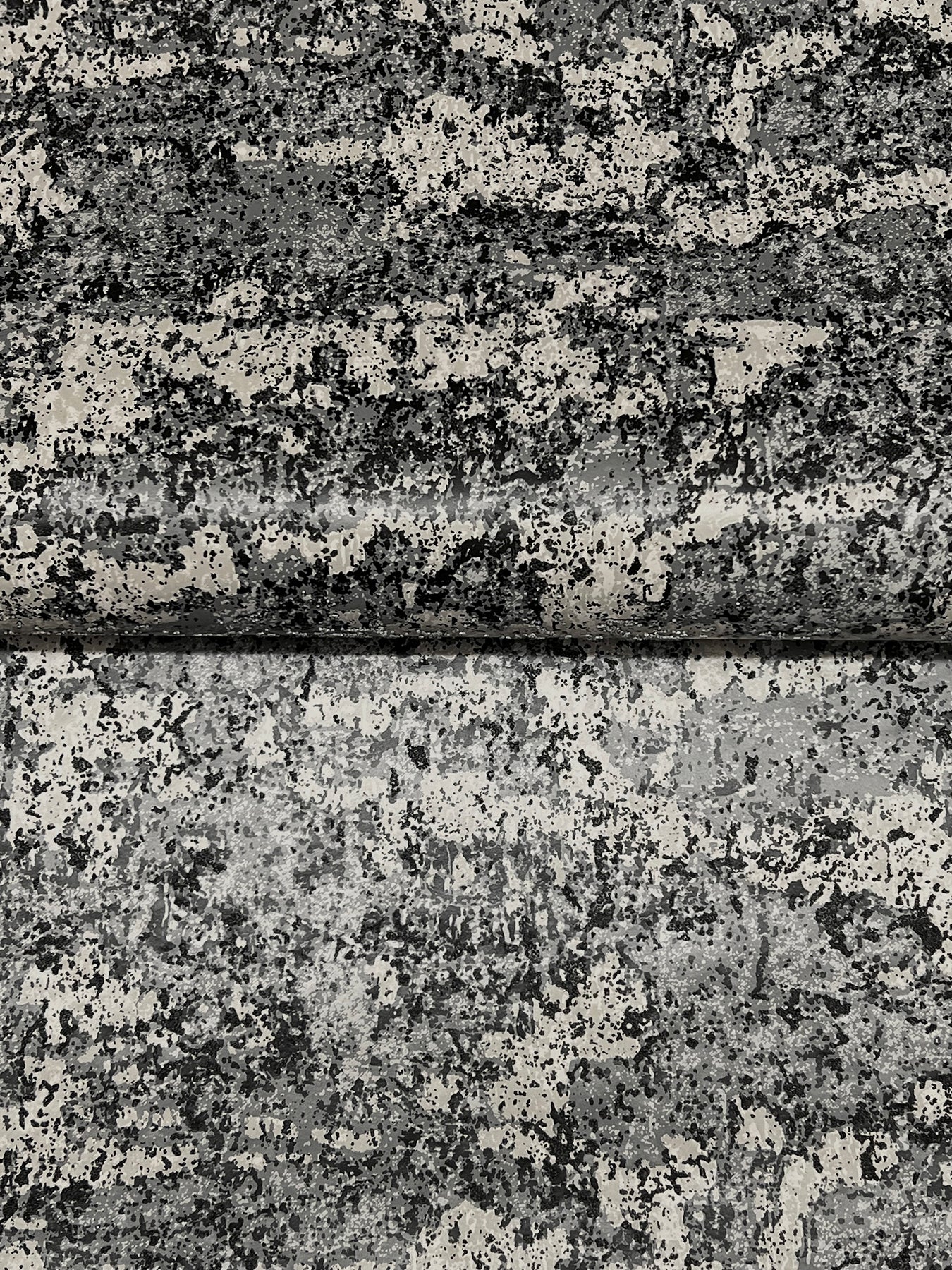 Close-up of charcoal gray beaded wallpaper texture with a subtle speckled pattern and a horizontal seam.