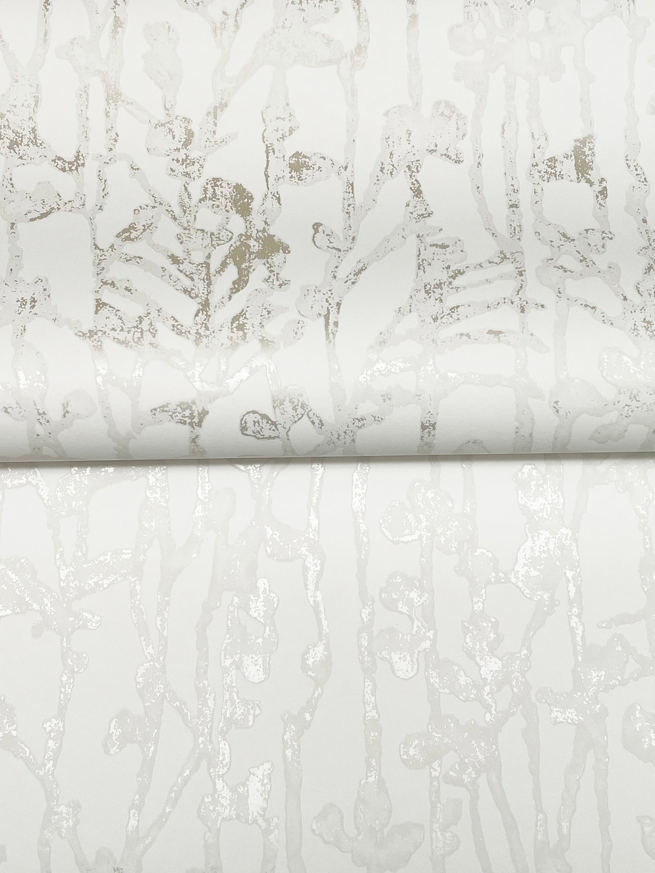 White pearl wallpaper with a subtle light gray filigree/abstract pattern and a slight metallic sheen, rolled edge visible