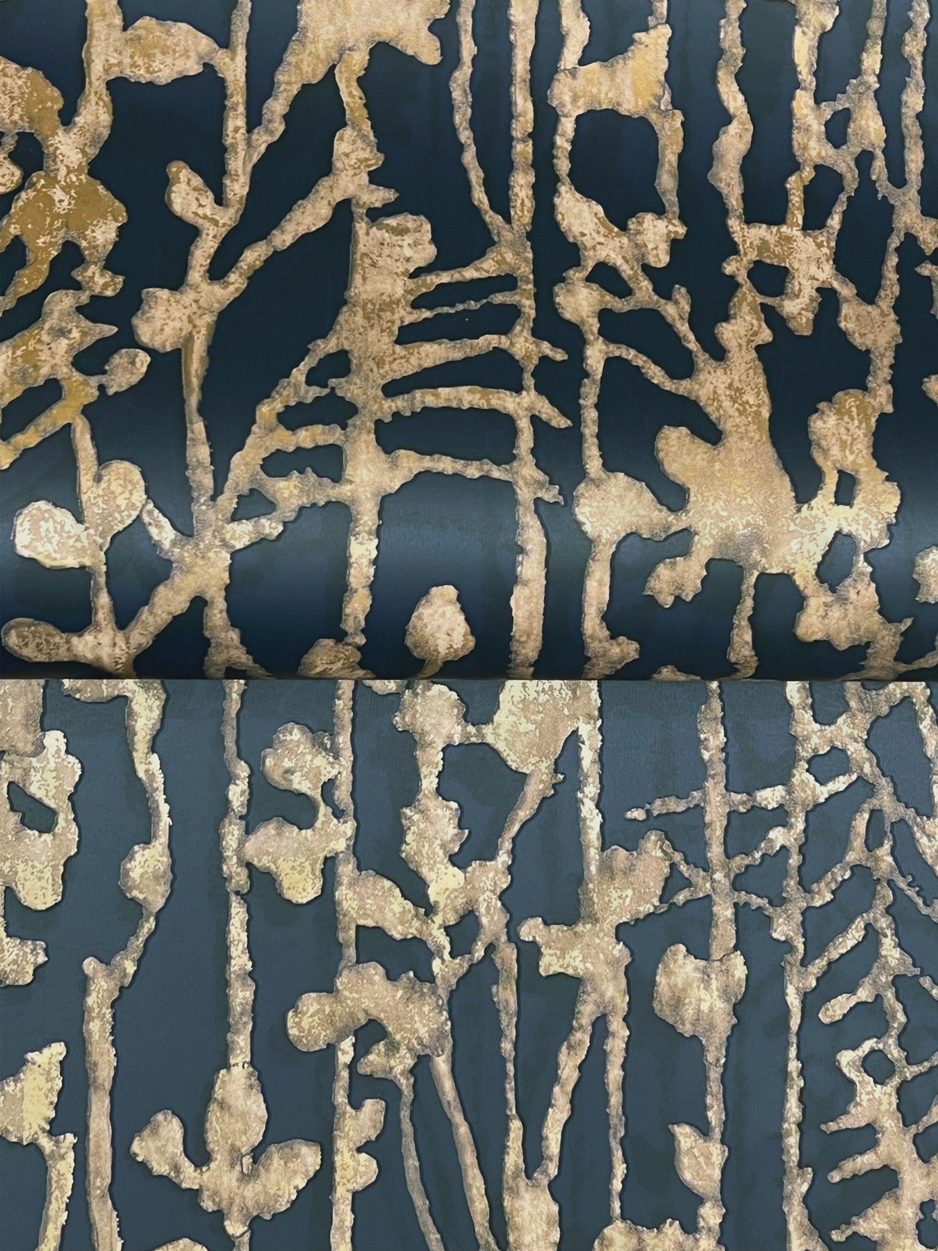 Close-up of navy wallpaper with metallic gold abstract filigree pattern and shimmering texture.