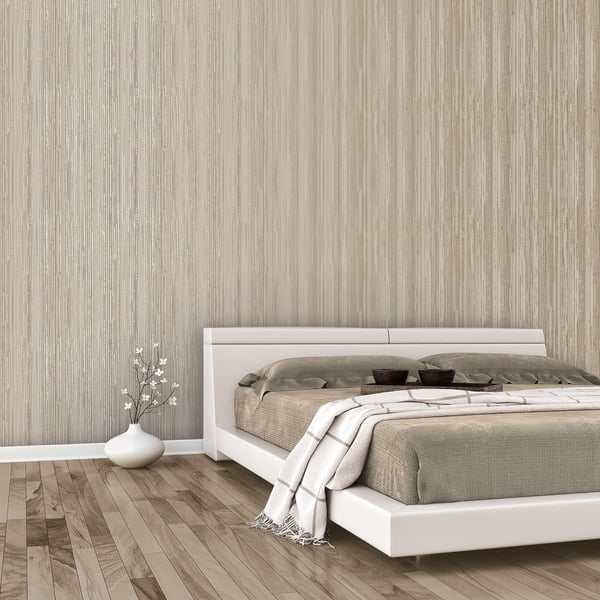 Modern white platform bed with beige bedding, gray throw, metallic gold abstract stripe wallpaper, wooden floor, and a vase with branches.