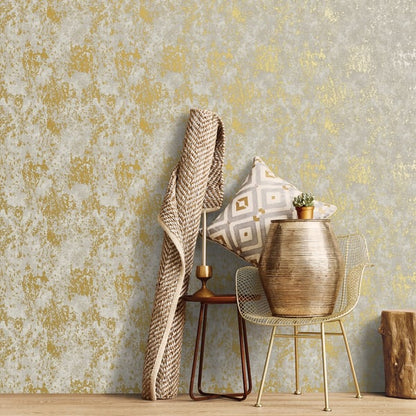 Beige knit throw over a wooden side table with geometric pillow and a gold ribbed vase with a cactus, beside a metal chair.