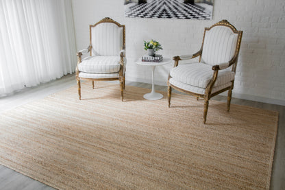 Beige jute runner rug on the floor with two white & gold carved chairs & a white round side table nearby.