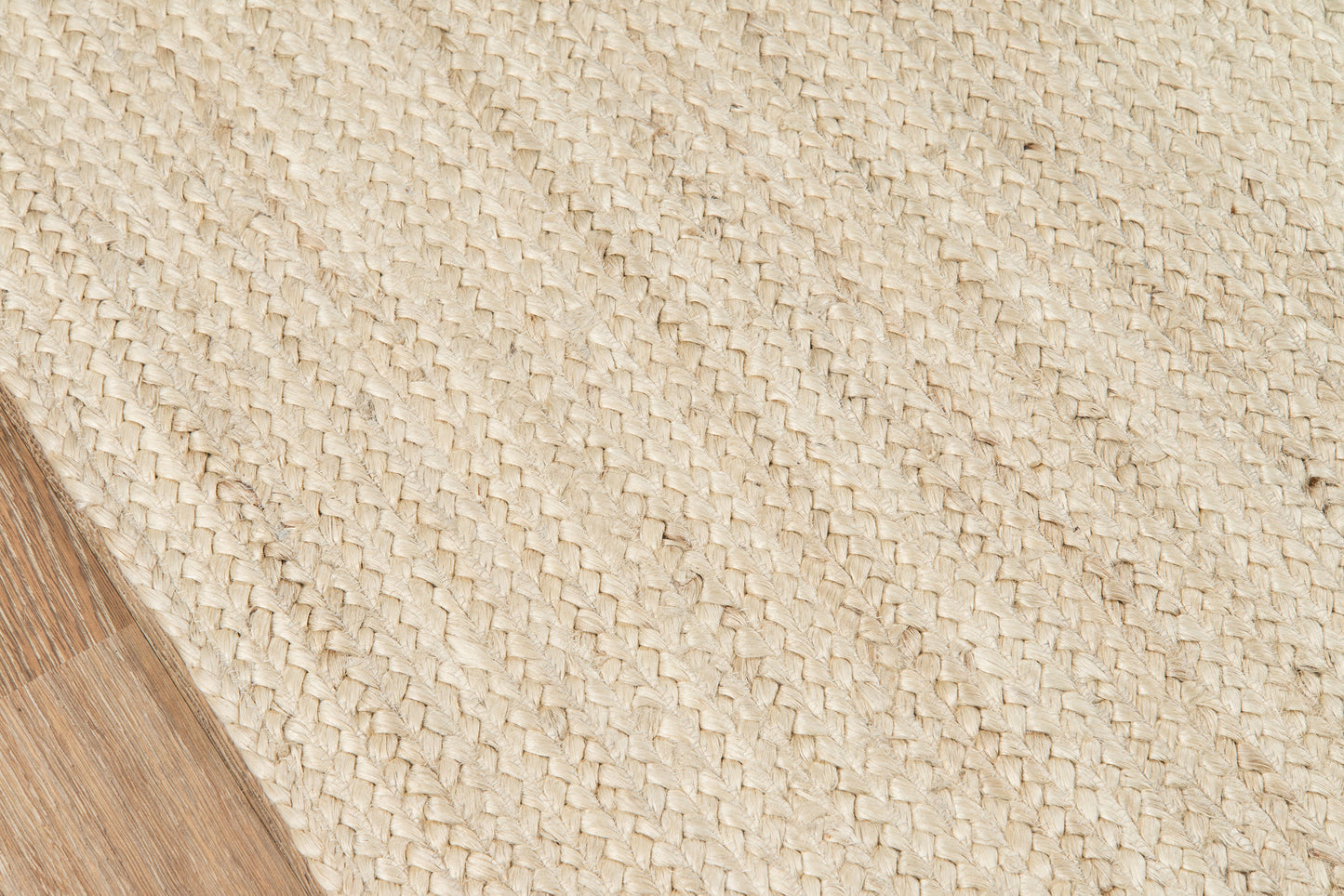 Natural beige woven jute runner; textured diagonal weave, corner on wooden floor, rustic & coastal style.