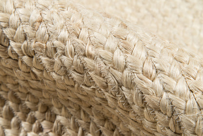 Close-up of natural beige straw weaving with thick braided fibers on a rug runner.