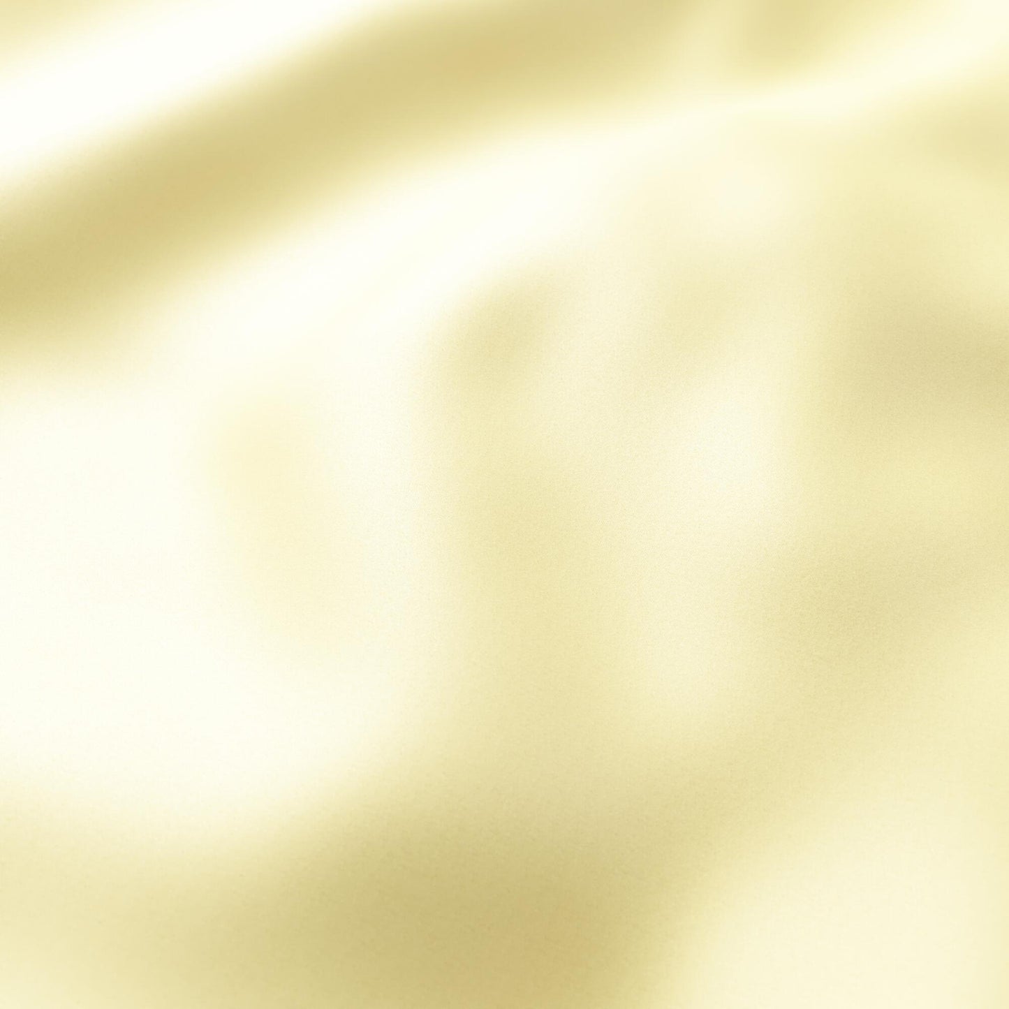 Soft yellow and lime sateen fabric with gentle folds and a warm, luminous sheen.