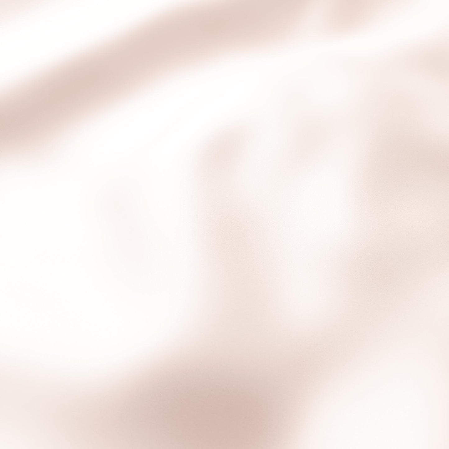 Soft peach and pink satin-like fabric with a blurred abstract texture.
