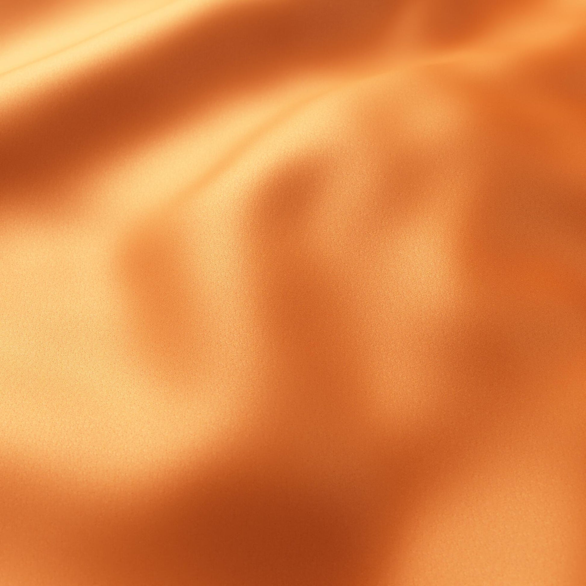 Orange satin fabric with smooth sheen and soft, flowing drapes.